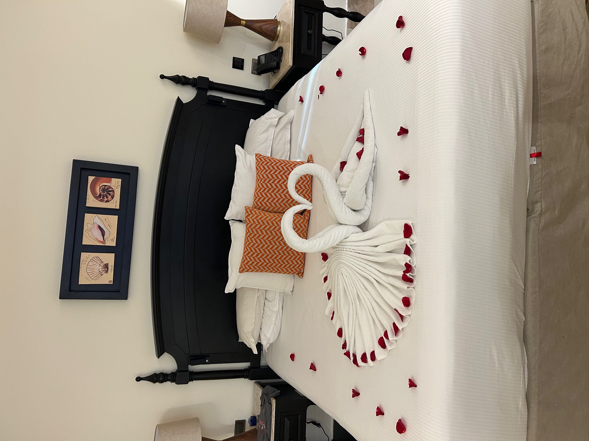 Romantic towel design with rose petals on the bed
